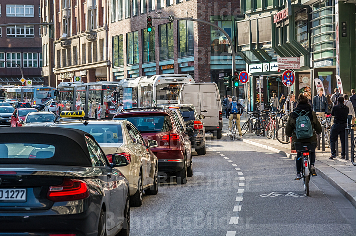 Eine Fahrradfahrerin fährt auf einem Schutzstreifen an einem Stau am Gänsemarkt in Hamburg vorbei