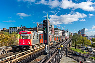 Ein U-Bahn-Zug der Baureihe DT3 auf der Viaduktstrecke im Hamburger Hafen vor der Elbphilharmonie