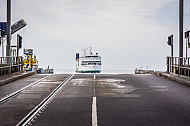 Eisenbahn- und LKW-Laderampe im dänischen Fährhafen Rödby an der Vogelfluglinie. Im Hintergrund die Scandlines-Fähre 