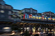 Ein U-Bahn-Zug vom Typ DT5 auf einem Viadukt im Hamburger Hafen am Baumwall