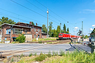 Regionalzug passiert Bahnübergang im Bahnhof Dauenhof in Schleswig-Holstein