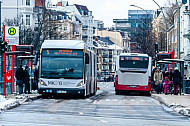 Menschen und Busse im Winter an einer Haltestelle in Hamburg