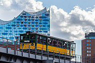 Ein historischer U-Bahnzug vom Typ T auf der Linie U3 vor der Elbphilharmonie in Hamburg