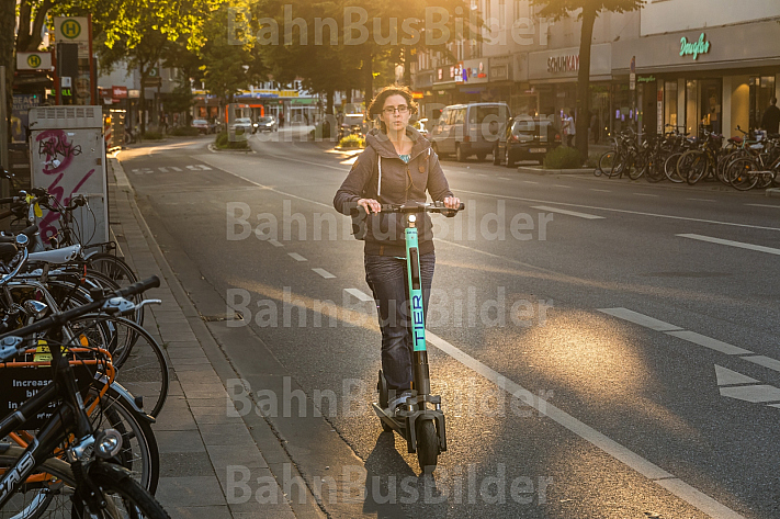 Eine E-Scooter-Fahrerin in der Abendsonne in der Osterstraße in Hamburg
