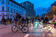 Zahlreiche Radfahrer überqueren im Abendlicht eine Hauptstraße in Hamburg