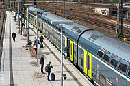Menschen stehen vor einem Doppelstockzug der Deutschen Bahn auf einem Bahnsteig im Hamburger Hauptbahnhof