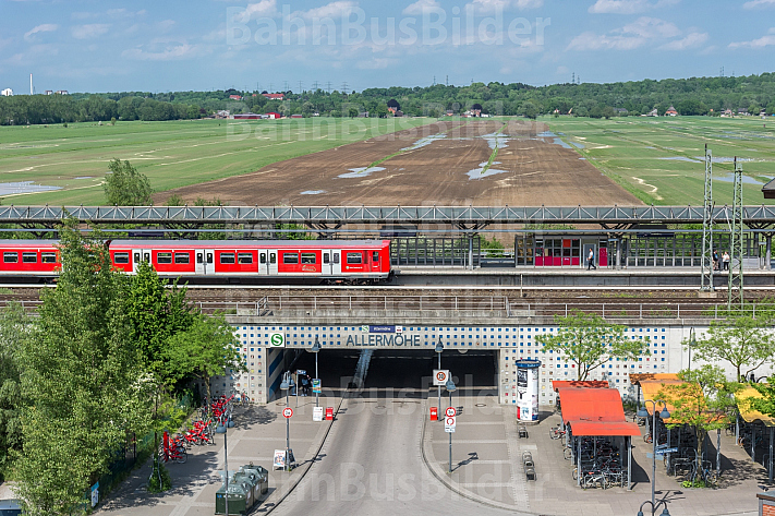 Der zukünftige Stadtteil Oberbillwerder in Hamburg(Hintergrund). Im Vordergrund hält eine S-Bahn in der Station Allermöhe