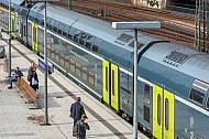 Menschen stehen vor einem Doppelstockzug der Deutschen Bahn auf einem Bahnsteig im Hamburger Hauptbahnhof