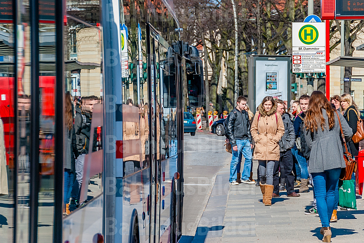 Menschen warten am Dammtor in Hamburg auf einen Metrobus