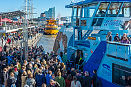 Eine Menschenmenge drängt an den Hamburger Landungsbrücken auf eine Hafenfähre der Linie 62