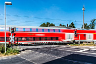 Regionalzug passiert Bahnübergang im Bahnhof Dauenhof in Schleswig-Holstein