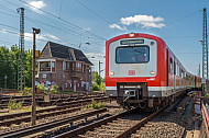 Ein S-Bahn-Zug der Baureihe 472 fährt in den Bahnhof Elbgaustraße ein. Im Hintergrund ein altes Stellwerk
