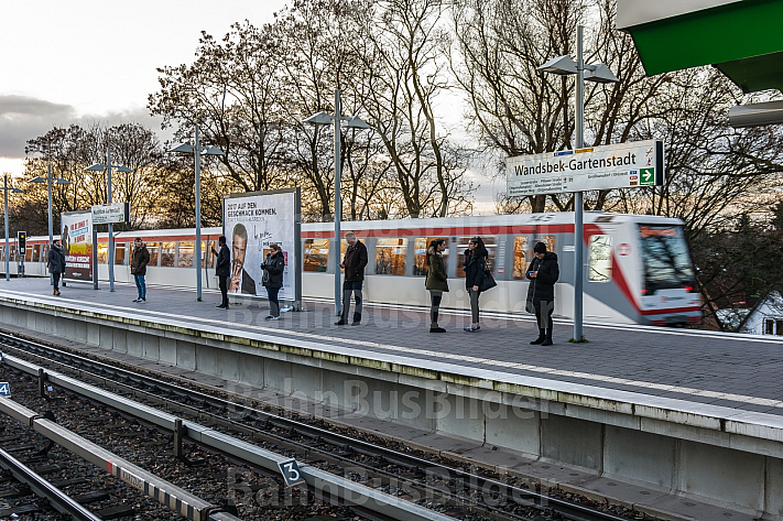 Menschen warten am U-Bahnhof Wandsbek-Gartenstadt in Hamburg auf ihren Zug