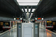 Zwei U-Bahn-Züge vom Typ DT4 in der Haltestelle HafenCity Universität in Hamburg mit einer Anzeigetafel im Vordergrund