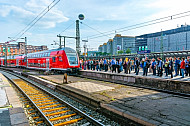 Menschen warten im Hamburger Hauptbahnhof auf einen Regionalexpress nach Lübeck