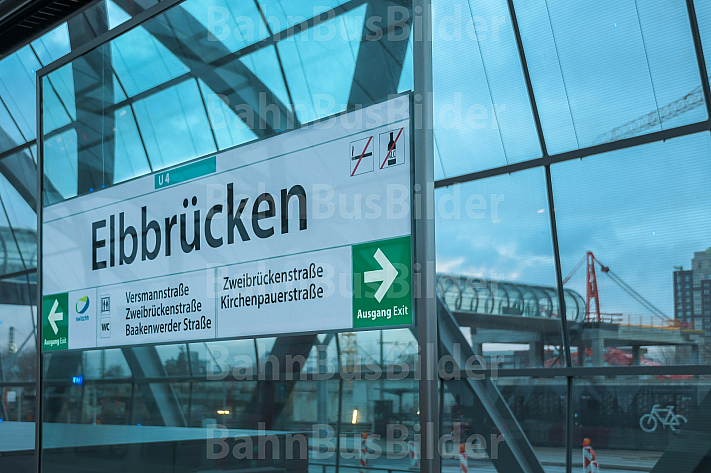 Ein Haltestellenschild im U-Bahnhof Elbbrücken in Hamburg - im Hintergrund die Baustelle für einen S-Bahnhof