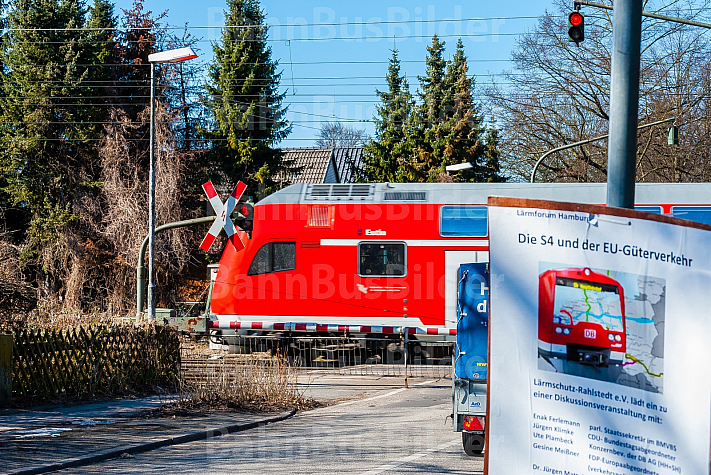 Regionalzug am Bahnübergang Claudiusstraße in Hamburg mit Plakat gegen die geplante S4