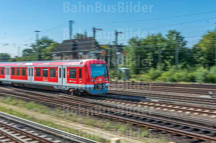 Ein S-Bahn-Zug der Baureihe 474 fährt in den Bahnhof Elbgaustraße ein. Im Hintergrund ein altes Stellwerk