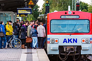 Menschen steigen in AKN-Triebwagen im S-Bahnhof Hamburg-Eidelstedt
