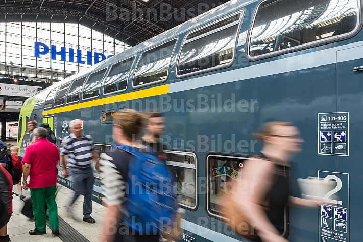 Menschen laufen im Hamburger Hauptbahnhof vor einem Doppelstock-Zug der Deutschen Bahn