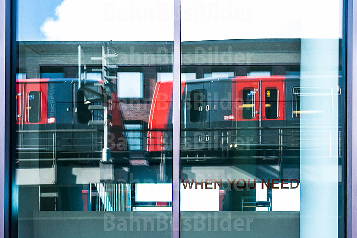 Zwei U-Bahnzüge vom Typ DT5 spiegeln sich in einem Bürogebäude in Hamburg
